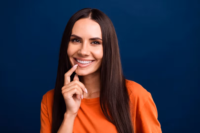 Woman smiling and touching her teeth
