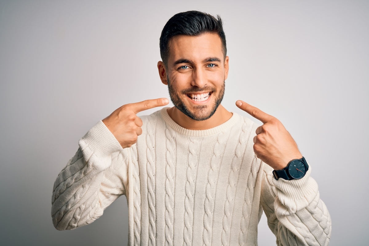 Man pointing to his healthy smile
